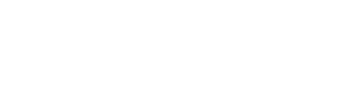 A black sign with white text that says Turnberry Creek Apartment Living.